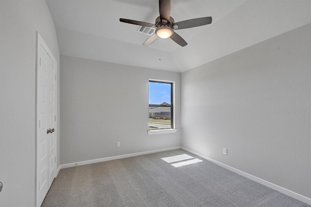 carpeted spare room with baseboards, visible vents, and ceiling fan