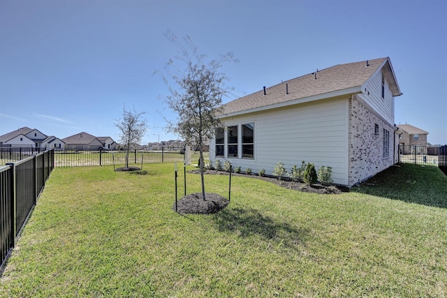 exterior space with a fenced backyard, a yard, and brick siding