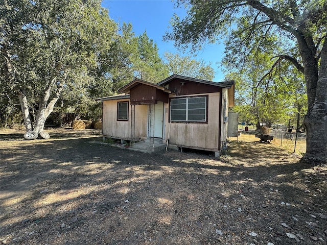 view of outdoor structure with entry steps and fence