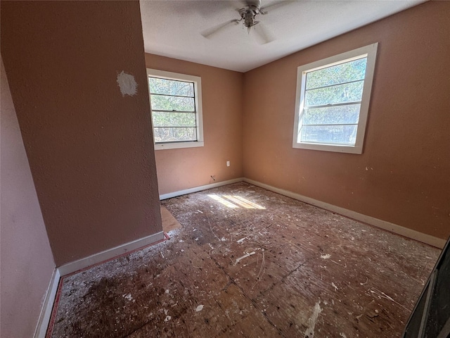 unfurnished room with ceiling fan and baseboards