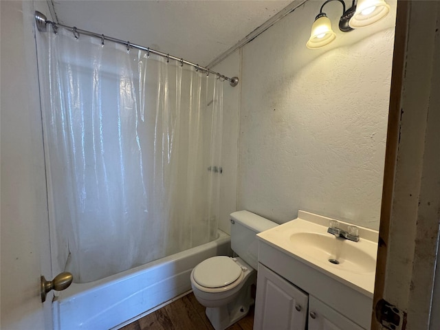 bathroom featuring shower / tub combo, a textured wall, toilet, wood finished floors, and vanity