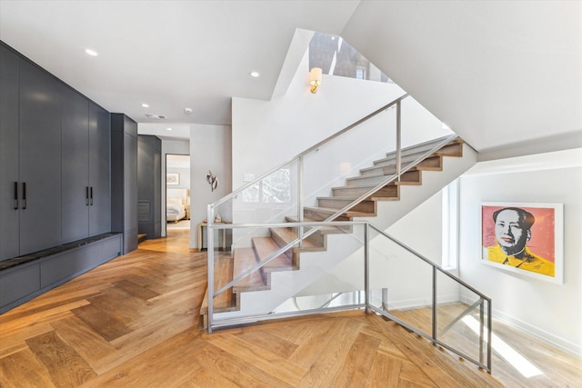 stairway with visible vents, baseboards, and recessed lighting