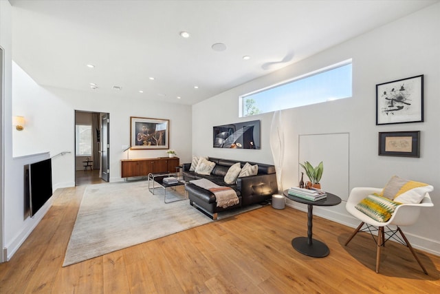 living area featuring light wood-style flooring, recessed lighting, a fireplace, visible vents, and baseboards