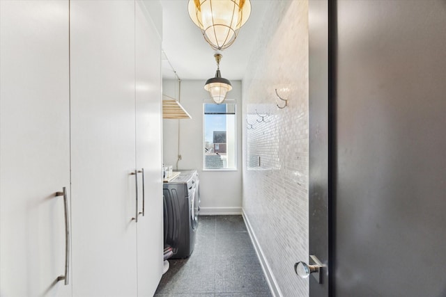 laundry area with laundry area, washer and clothes dryer, and baseboards