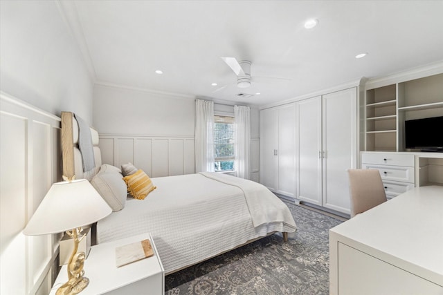 bedroom featuring crown molding, recessed lighting, a decorative wall, a ceiling fan, and wainscoting