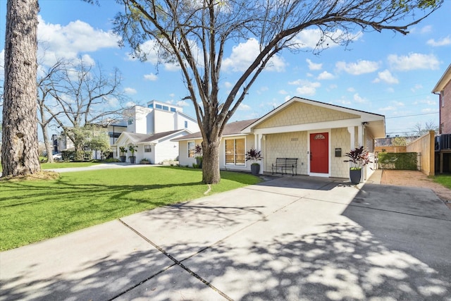 view of front of house featuring central AC unit, a residential view, fence, and a front lawn