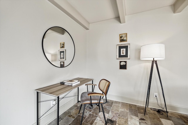 office area with baseboards, stone finish floor, and beamed ceiling