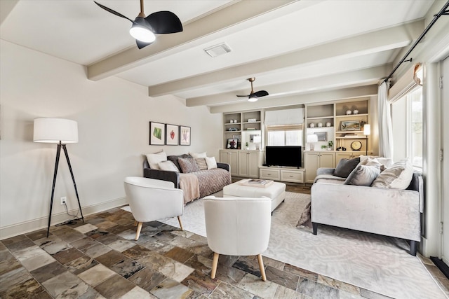 living room with visible vents, baseboards, a ceiling fan, stone finish floor, and beamed ceiling