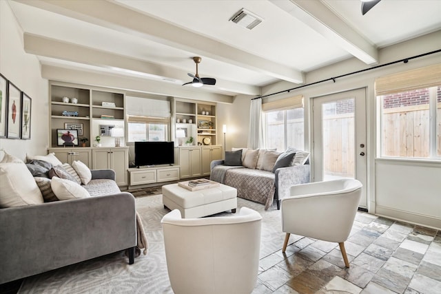 living area with baseboards, visible vents, ceiling fan, beamed ceiling, and stone finish flooring