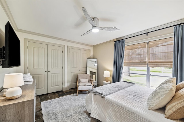 bedroom featuring crown molding, ceiling fan, and two closets