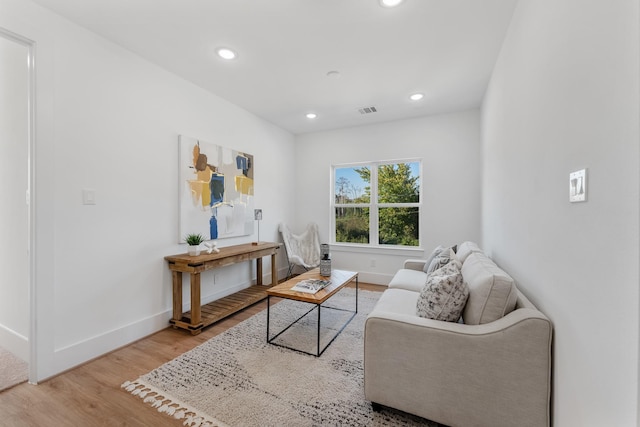 living room with recessed lighting, light wood-type flooring, visible vents, and baseboards