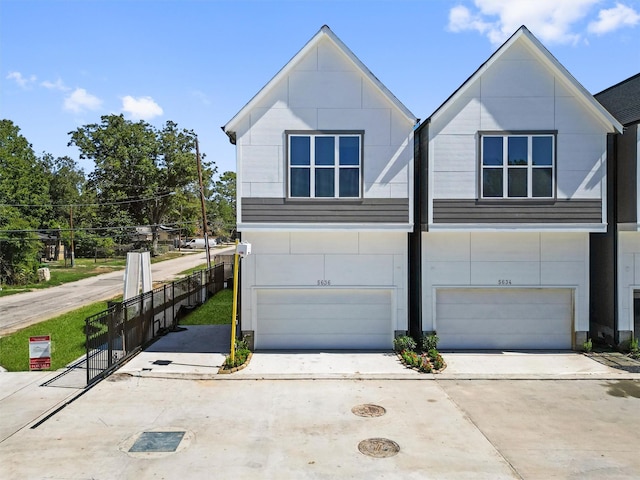 view of front of house with a garage, driveway, and fence