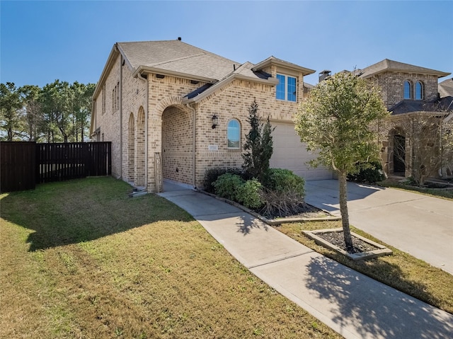 french provincial home featuring brick siding, driveway, a front yard, and fence