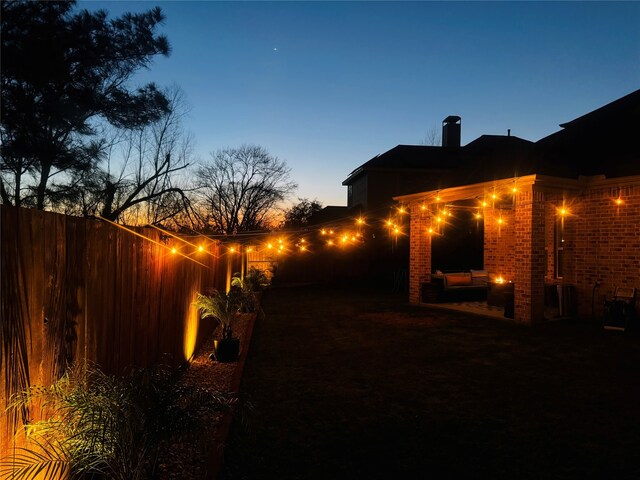 yard at dusk featuring fence