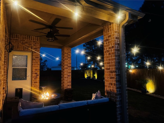 patio at twilight featuring a ceiling fan and fence