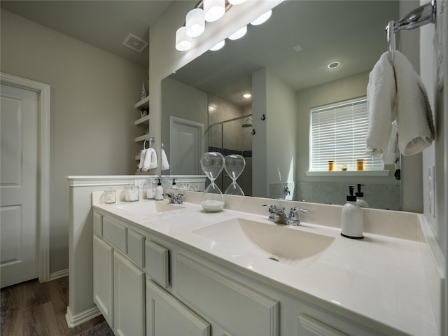 full bath with double vanity, visible vents, a shower stall, and a sink