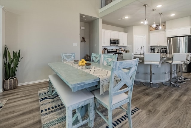 dining area featuring recessed lighting, baseboards, and wood finished floors