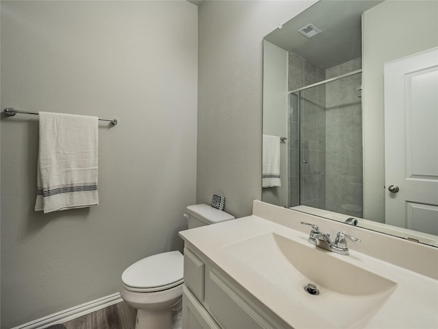 full bathroom with vanity, wood finished floors, visible vents, tiled shower, and toilet