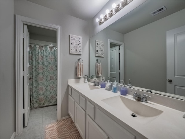 full bath featuring tile patterned floors, visible vents, double vanity, and a sink