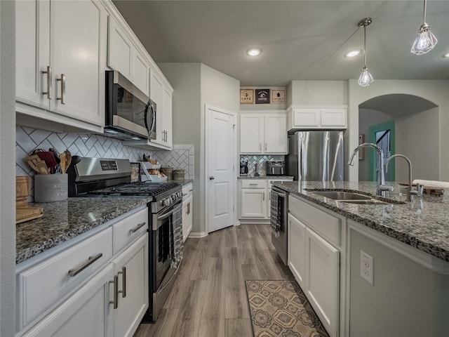 kitchen featuring dark wood-style flooring, white cabinetry, stainless steel appliances, and a sink