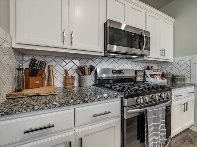 kitchen with white cabinetry, dark stone countertops, appliances with stainless steel finishes, and decorative backsplash