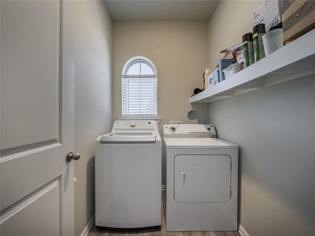 washroom featuring laundry area, baseboards, and separate washer and dryer