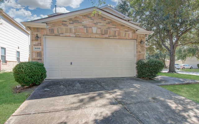 garage featuring concrete driveway