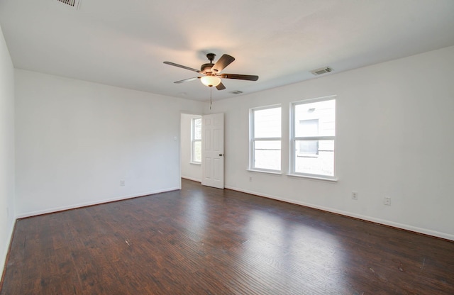 unfurnished room with a ceiling fan, baseboards, visible vents, and dark wood-style flooring