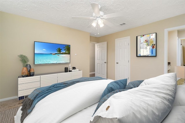 carpeted bedroom with a textured ceiling, visible vents, a ceiling fan, and baseboards