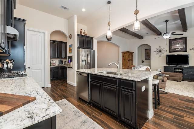 kitchen featuring appliances with stainless steel finishes, arched walkways, visible vents, and dark cabinets