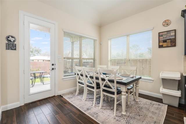 dining area featuring dark wood-style flooring and baseboards