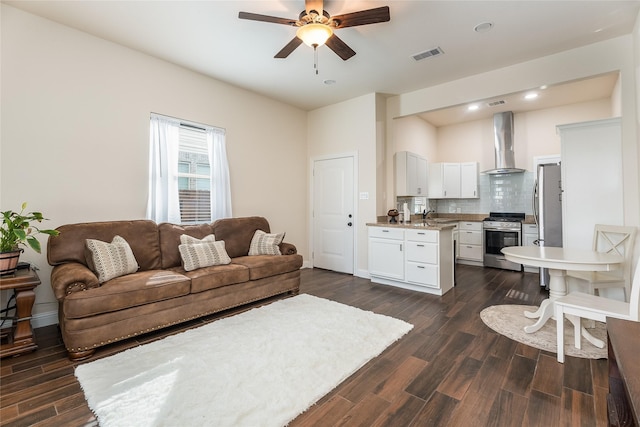 living room featuring a ceiling fan, visible vents, dark wood finished floors, and baseboards