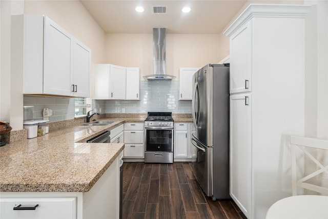 kitchen featuring stainless steel appliances, a sink, visible vents, wall chimney range hood, and wood tiled floor