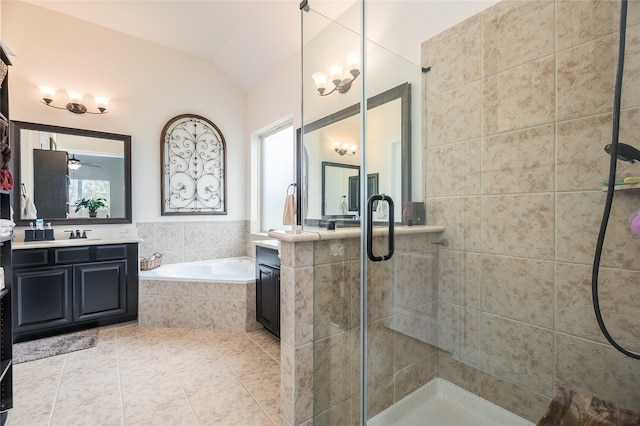 bathroom featuring a garden tub, lofted ceiling, two vanities, a stall shower, and tile patterned flooring