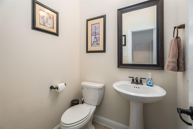 half bath with toilet and baseboards