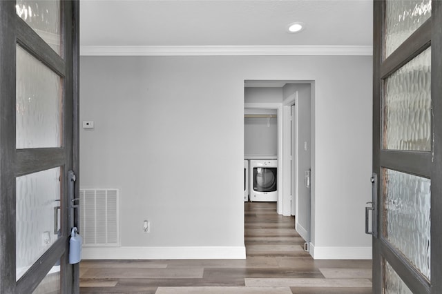 entryway with washer / dryer, visible vents, ornamental molding, and wood finished floors