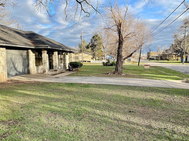 view of yard with an attached garage and driveway