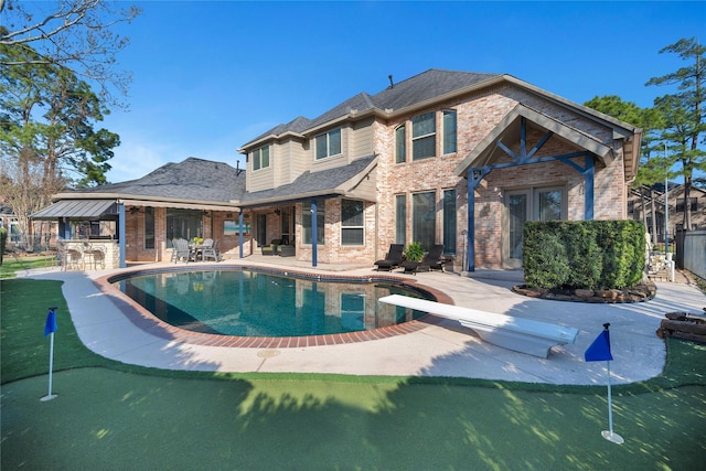 back of house featuring outdoor dry bar, an outdoor pool, brick siding, and a patio