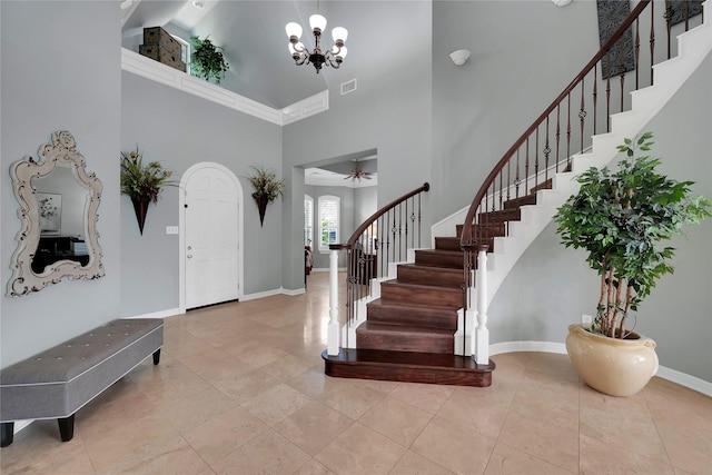 foyer with tile patterned floors, visible vents, baseboards, a towering ceiling, and stairs