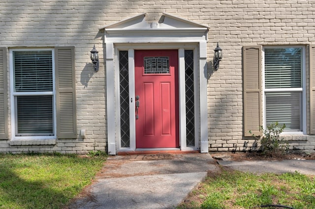 entrance to property featuring brick siding