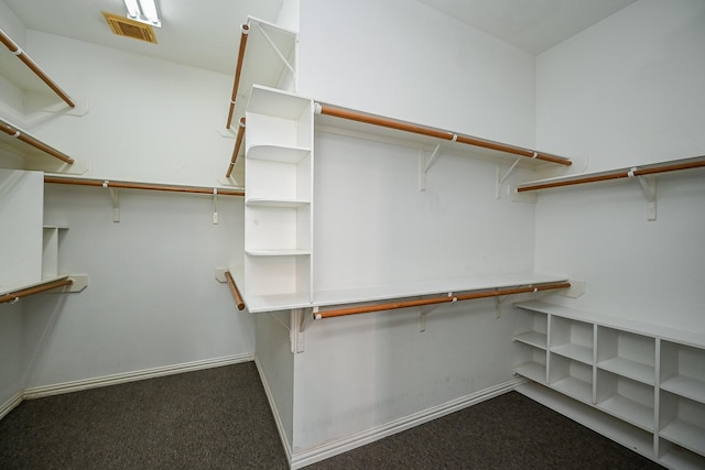 spacious closet featuring visible vents and dark carpet