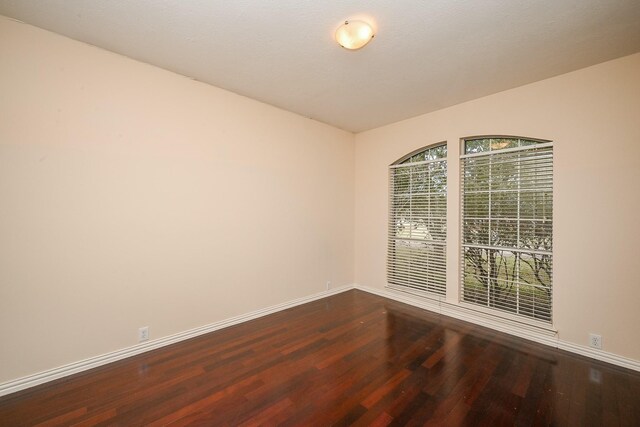 empty room with wood finished floors and baseboards