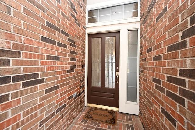 property entrance featuring brick siding