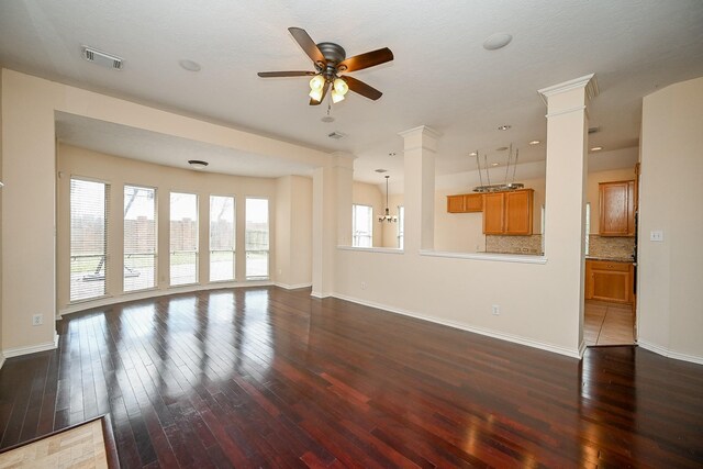 unfurnished living room featuring ornate columns, wood-type flooring, visible vents, and a ceiling fan