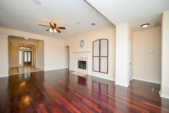 unfurnished living room featuring baseboards, a fireplace, hardwood / wood-style floors, and ceiling fan