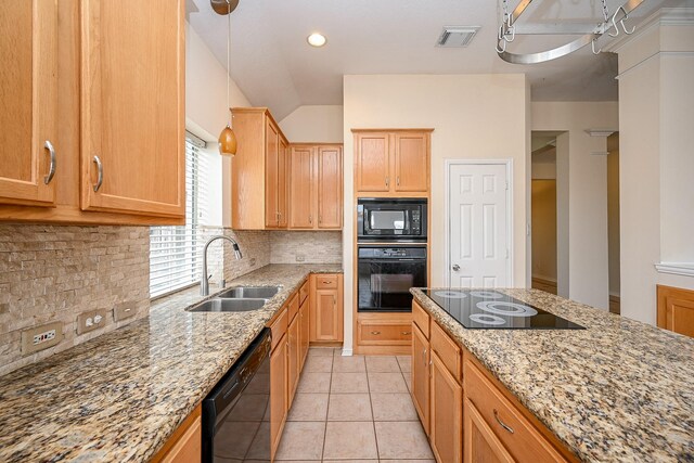 kitchen featuring light tile patterned floors, light stone counters, a sink, black appliances, and backsplash