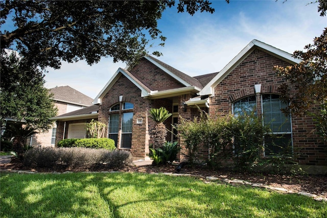 view of front of property featuring a garage, brick siding, and a front lawn