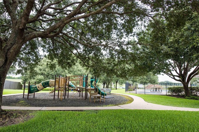 communal playground with a lawn and fence