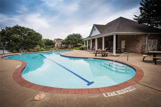 community pool featuring a patio area and fence