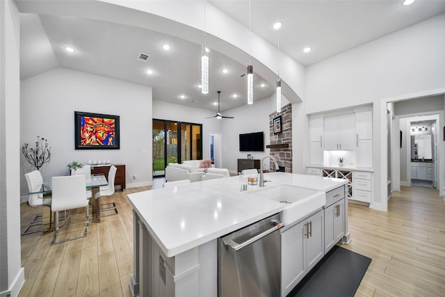 kitchen with light wood-type flooring, visible vents, a sink, and stainless steel dishwasher